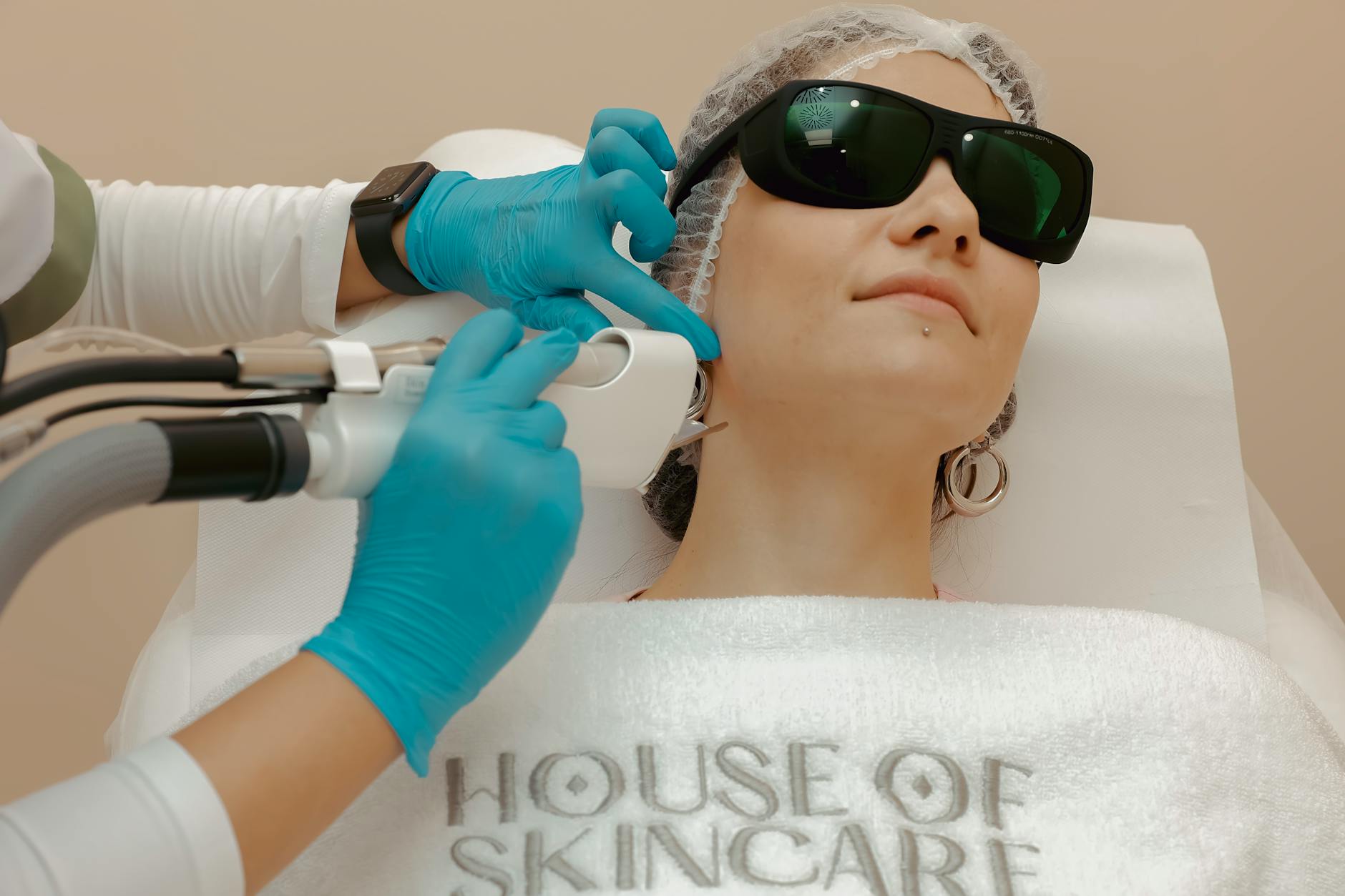 A woman receiving a laser skincare treatment in a beauty clinic.