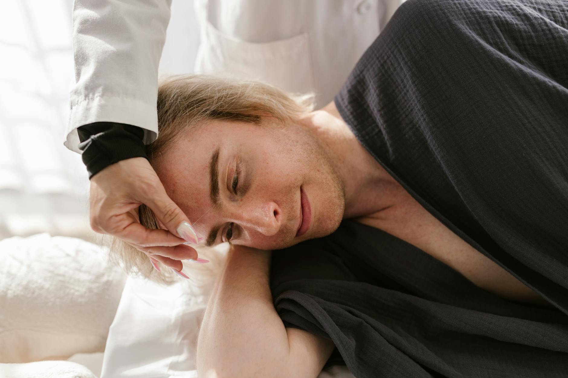 A man receiving acupuncture therapy indoors for relaxation and wellness.